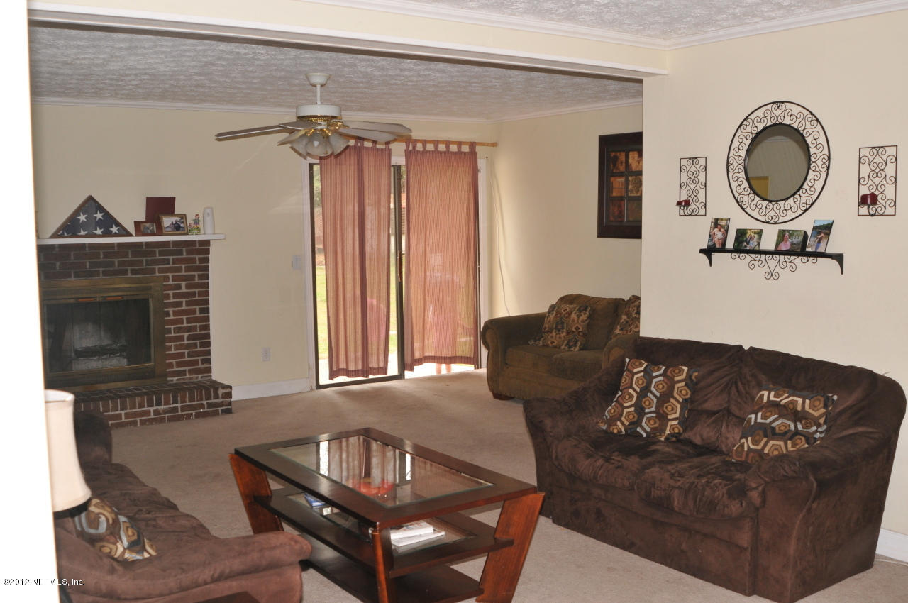 12945 Mandarin Road Jacksonville, FL 32223 - Photo 3 of 15 a living room with furniture a window and a fireplace