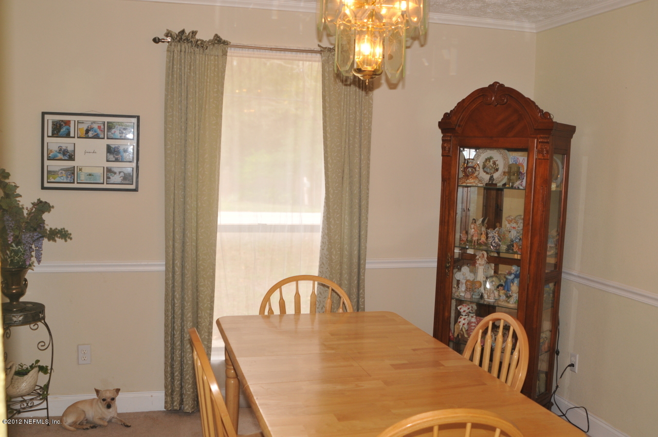 12945 Mandarin Road Jacksonville, FL 32223 - Photo 4 of 15 a view of a dining room with furniture and chandelier