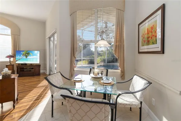 a view of a dining room with furniture a chandelier and wooden floor
