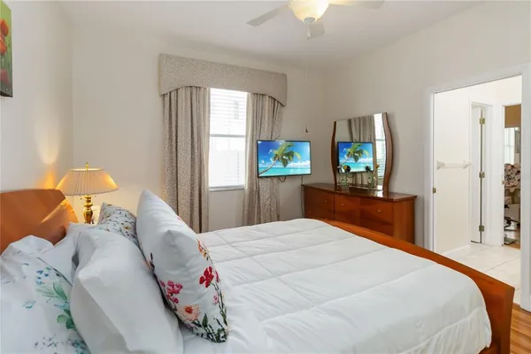 a bedroom with a bed and a flat tv screen on dresser