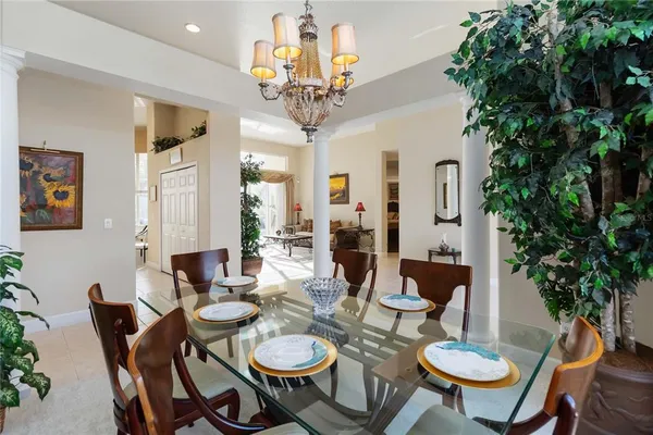 a view of a dining room with furniture a chandelier and wooden floor