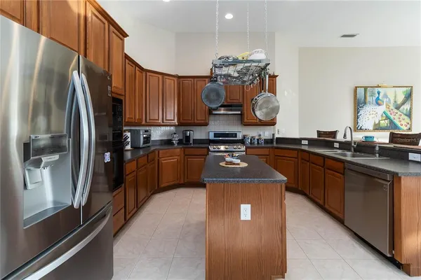 a kitchen with stainless steel appliances granite countertop a sink a stove and a refrigerator