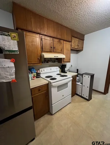 a kitchen with stainless steel appliances a refrigerator sink and cabinets