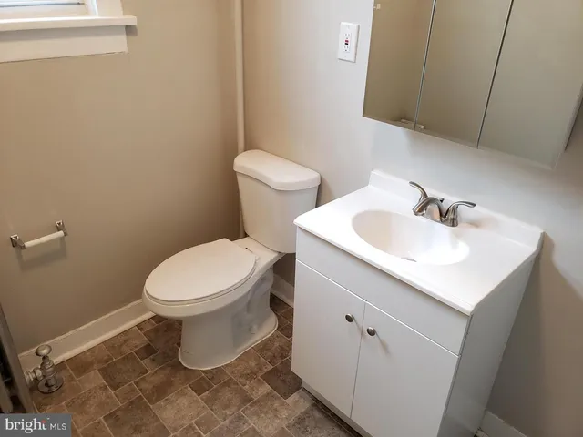 a white toilet sitting next to a bathroom sink