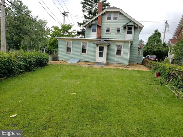 a white house sitting in middle of the grass