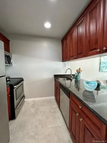 a kitchen with granite countertop a sink stove and cabinets