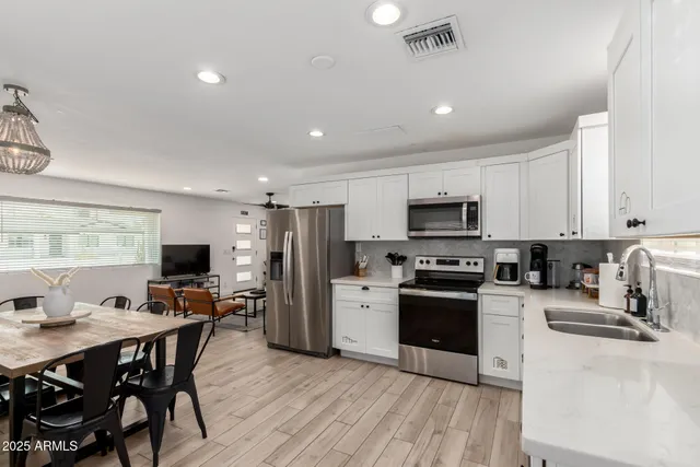 a kitchen with stainless steel appliances a refrigerator sink and microwave