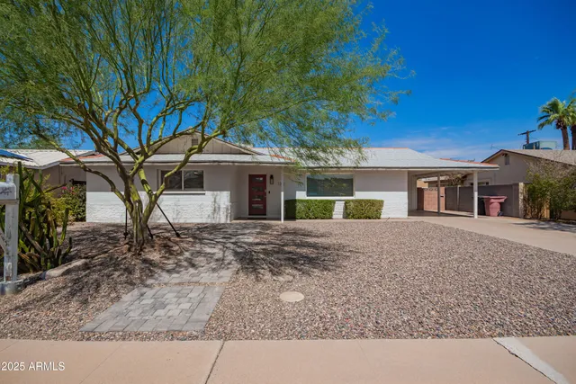 a front view of a house with a garden and yard