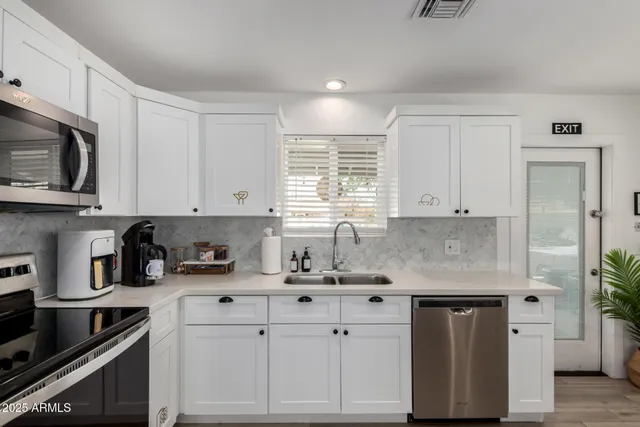 a kitchen with stainless steel appliances a refrigerator sink and microwave