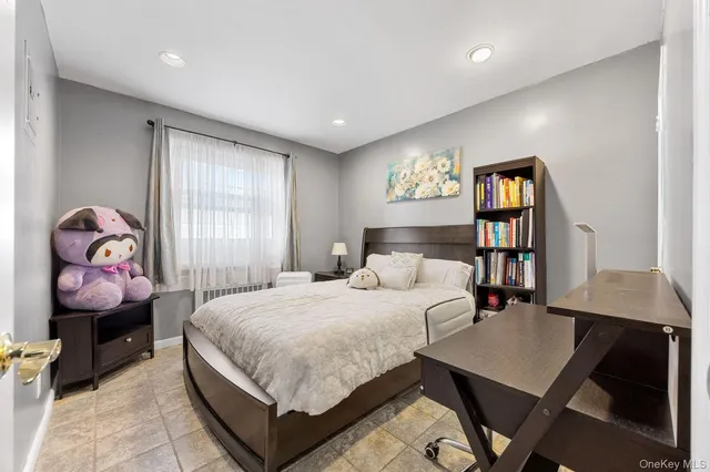 a bedroom with a bed a dresser and next to a window