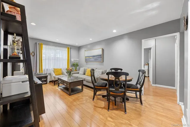 a living room with furniture and a dining table next to a window