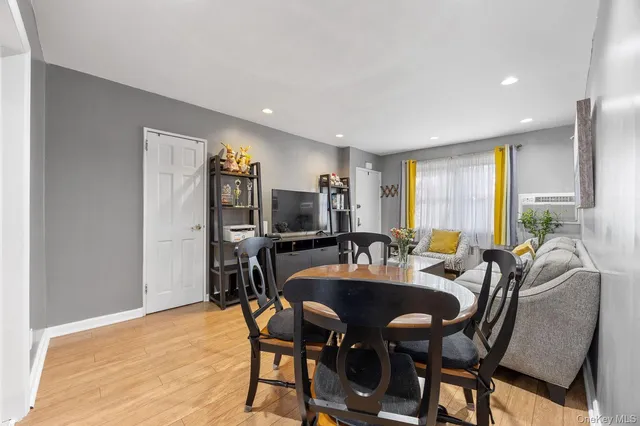 a view of a a dining room with furniture window and wooden floor