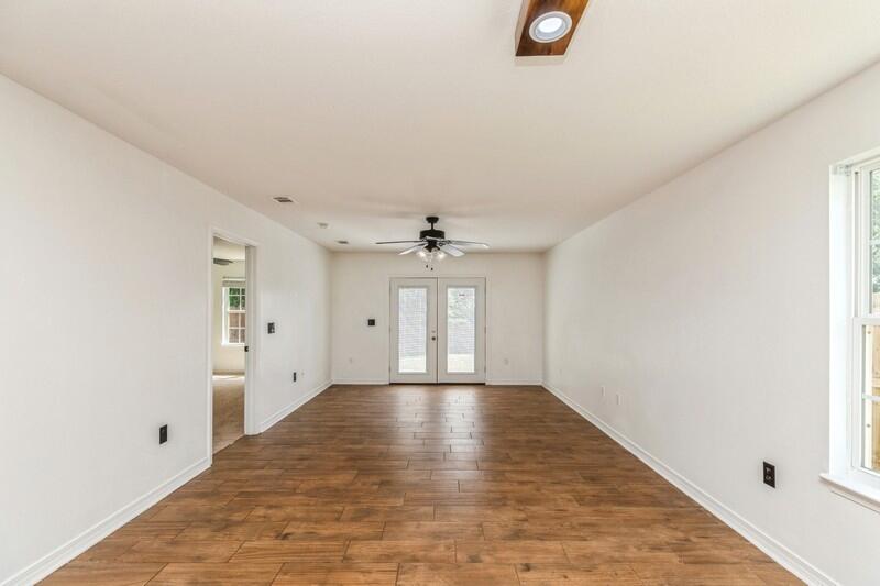 412 Eisenhower Drive Crestview, FL 32539 - Photo 11 of 35 wooden floor in an empty room with a window