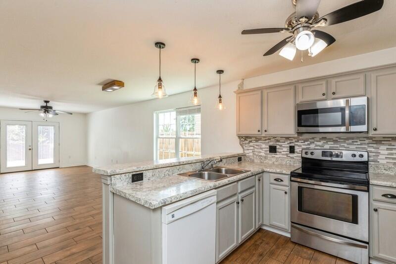 412 Eisenhower Drive Crestview, FL 32539 - Photo 3 of 35 a kitchen with granite countertop a sink stainless steel appliances and white cabinets