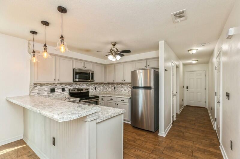 412 Eisenhower Drive Crestview, FL 32539 - Photo 6 of 35 a kitchen with stainless steel appliances granite countertop a refrigerator a stove a sink and a wooden floors