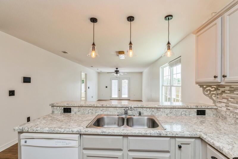 412 Eisenhower Drive Crestview, FL 32539 - Photo 7 of 35 a kitchen with granite countertop a sink a counter top space and cabinets