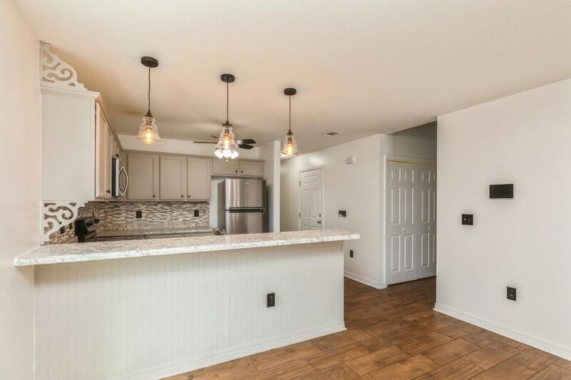 412 Eisenhower Drive Crestview, FL 32539 - Photo 10 of 35 a view of a kitchen with kitchen island a sink a refrigerator and wooden floor