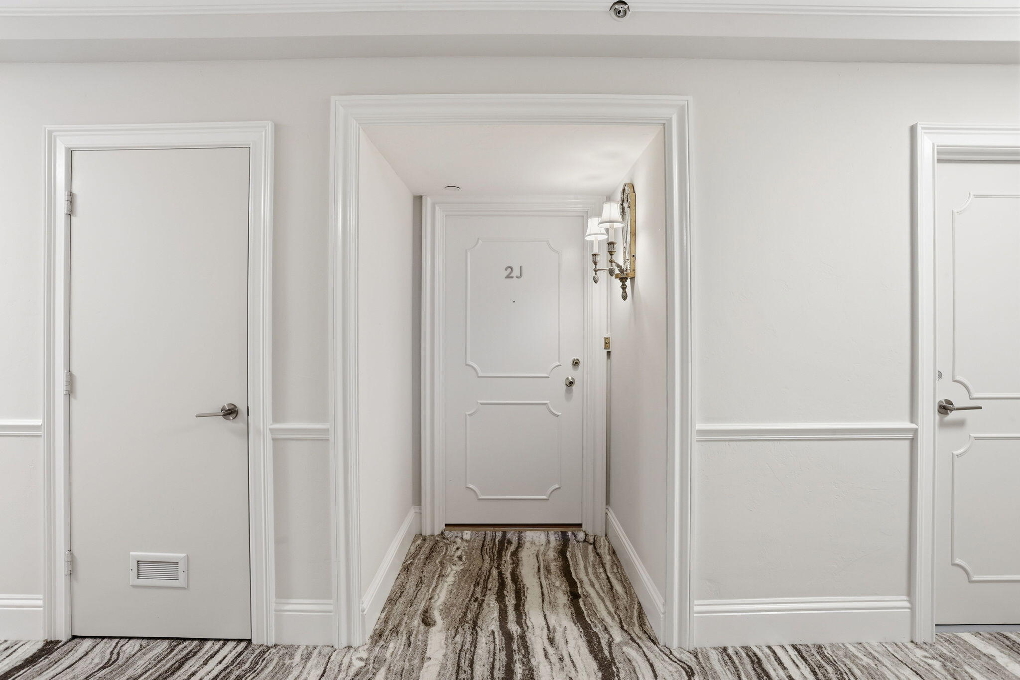 701 East Camino Real, Unit 2J Boca Raton, FL 33432 - Photo 32 of 51 a view of a hallway with wooden floor and a bathroom