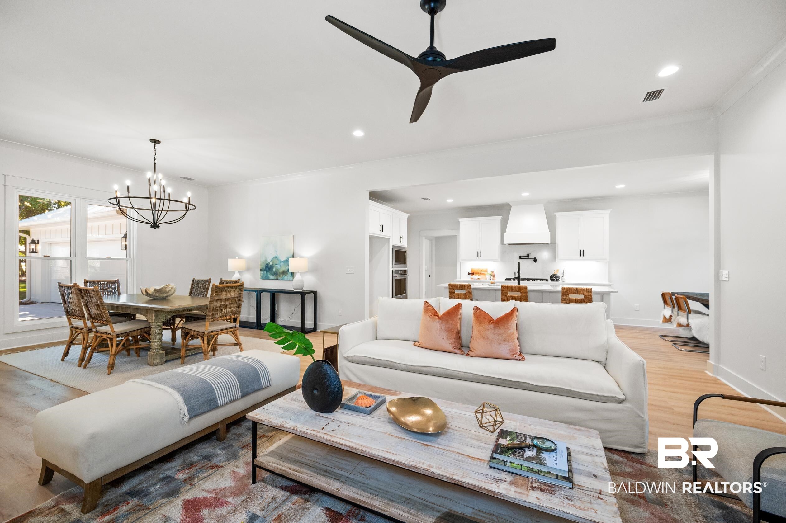 28889 Canal Road Orange Beach, AL 36561 - Photo 8 of 55 Living room featuring ceiling fan with notable chandelier, light hardwood / wood-style flooring, and ornamental molding