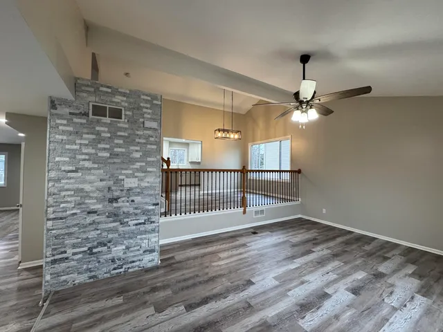 en empty room with stairs and wooden floor