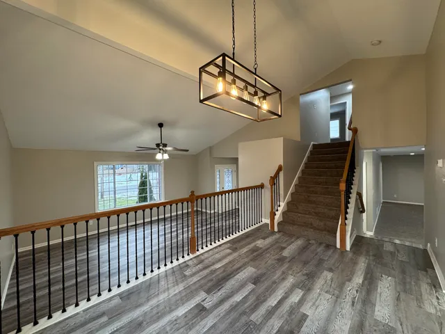 a view of staircase with wooden floor and fan