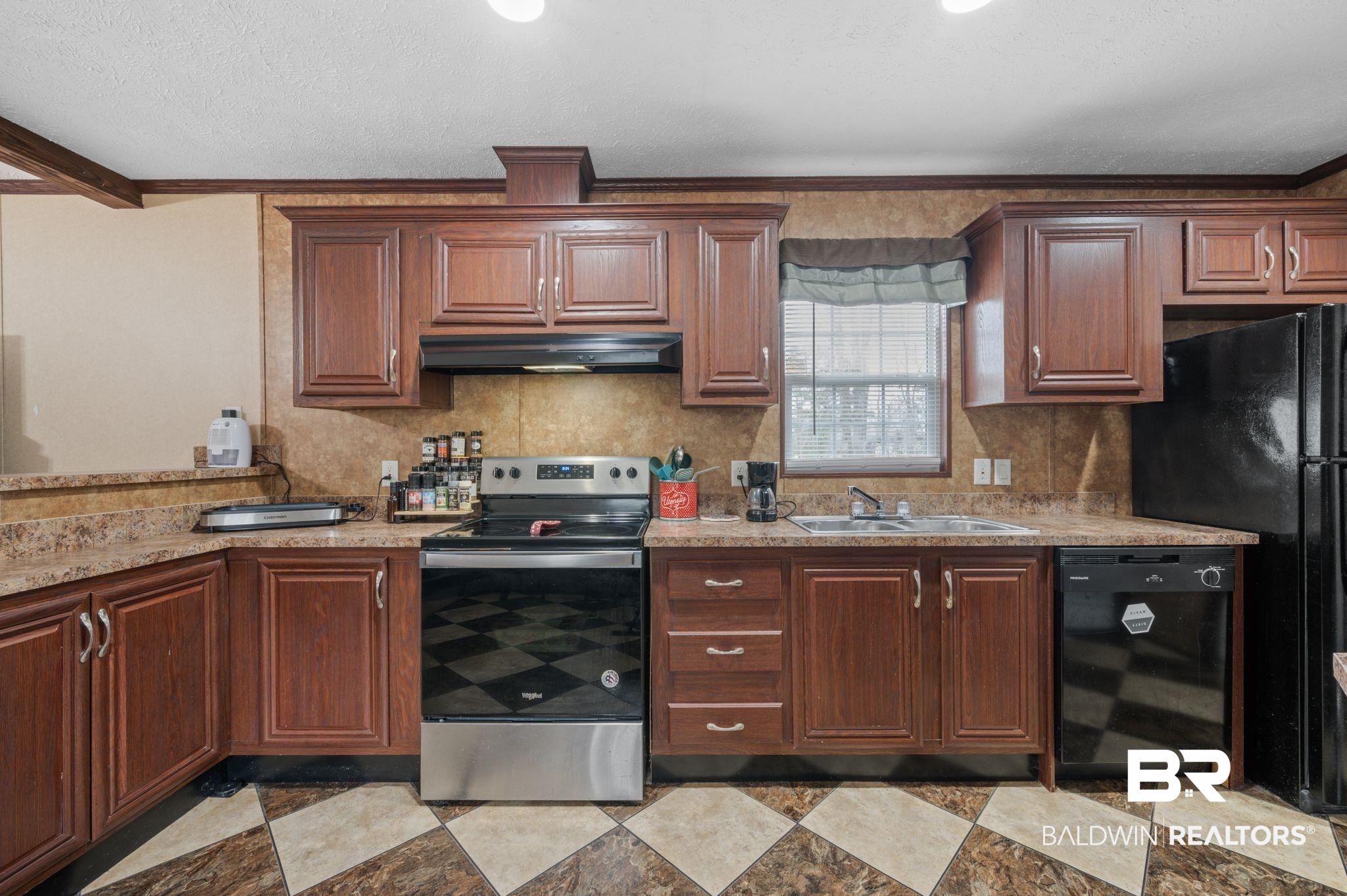 39908 T A Chastang Road Bay Minette, AL 36507 - Photo 8 of 20 Kitchen with ornamental molding, under cabinet range hood, a textured ceiling, black appliances, and a sink