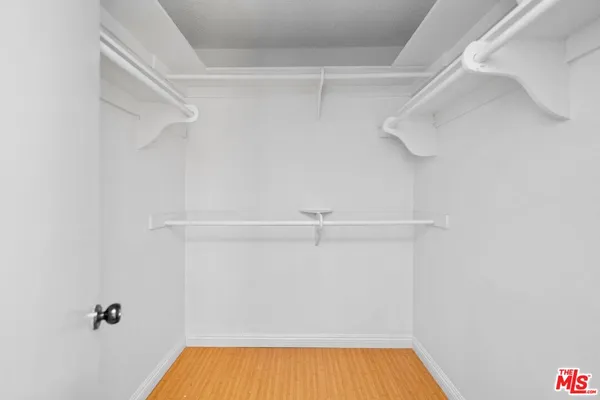 a view of walk in closet with empty racks