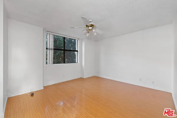 a bedroom with a window and ceiling fan