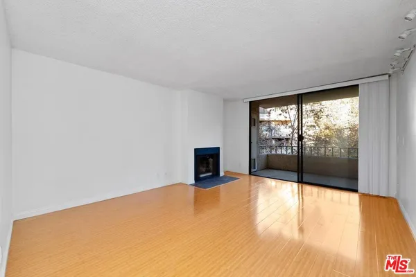 a view of an empty room with a fireplace and a window