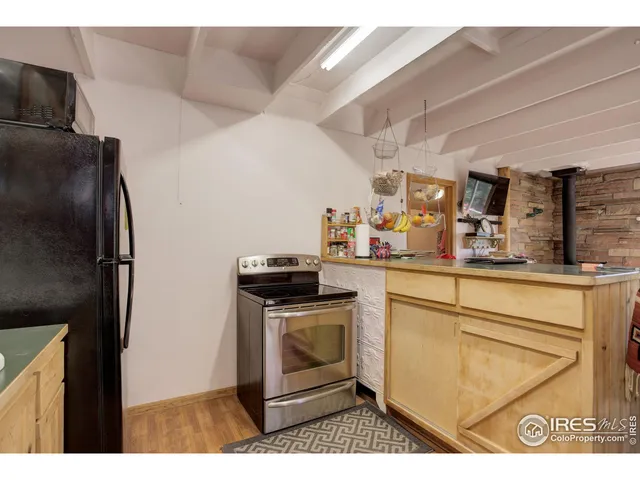 a utility room with stainless steel appliances wooden floor a sink and a large window