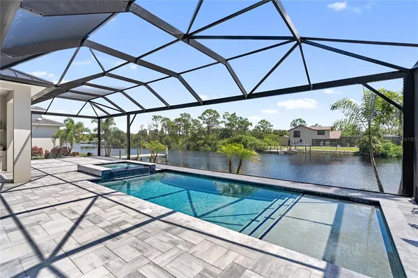 a view of a swimming pool with a table and chairs under an umbrella