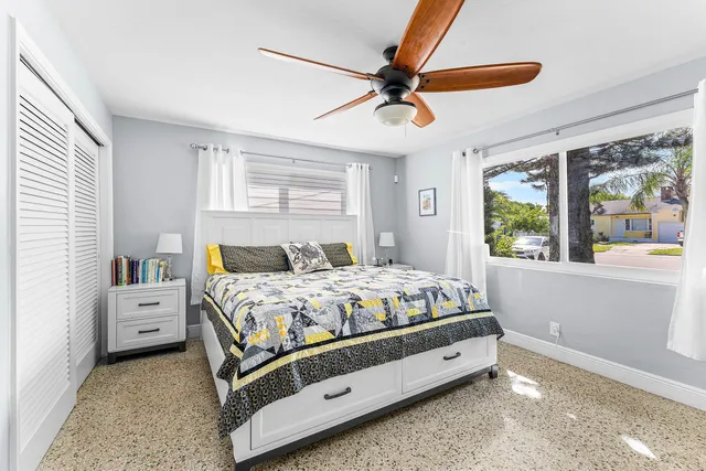 a bedroom with a bed and a large window