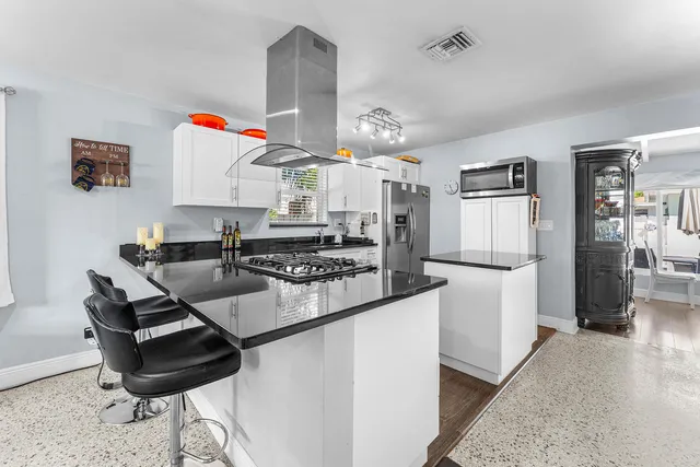 a kitchen with a sink a stove and chairs