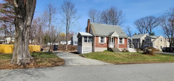 a view of a house with a big yard and large trees