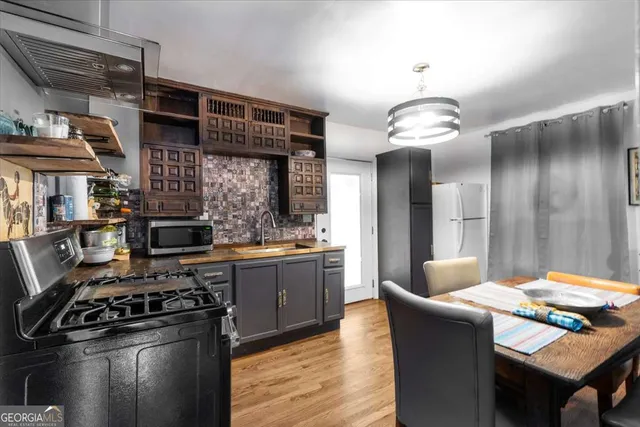 a kitchen with stainless steel appliances granite countertop a stove and a wooden floors