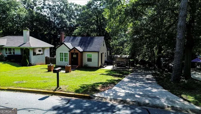 a view of a house with backyard and sitting area