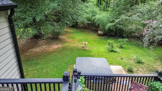 aerial view of a house with a yard and large trees