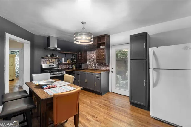 a kitchen with refrigerator and wooden floor