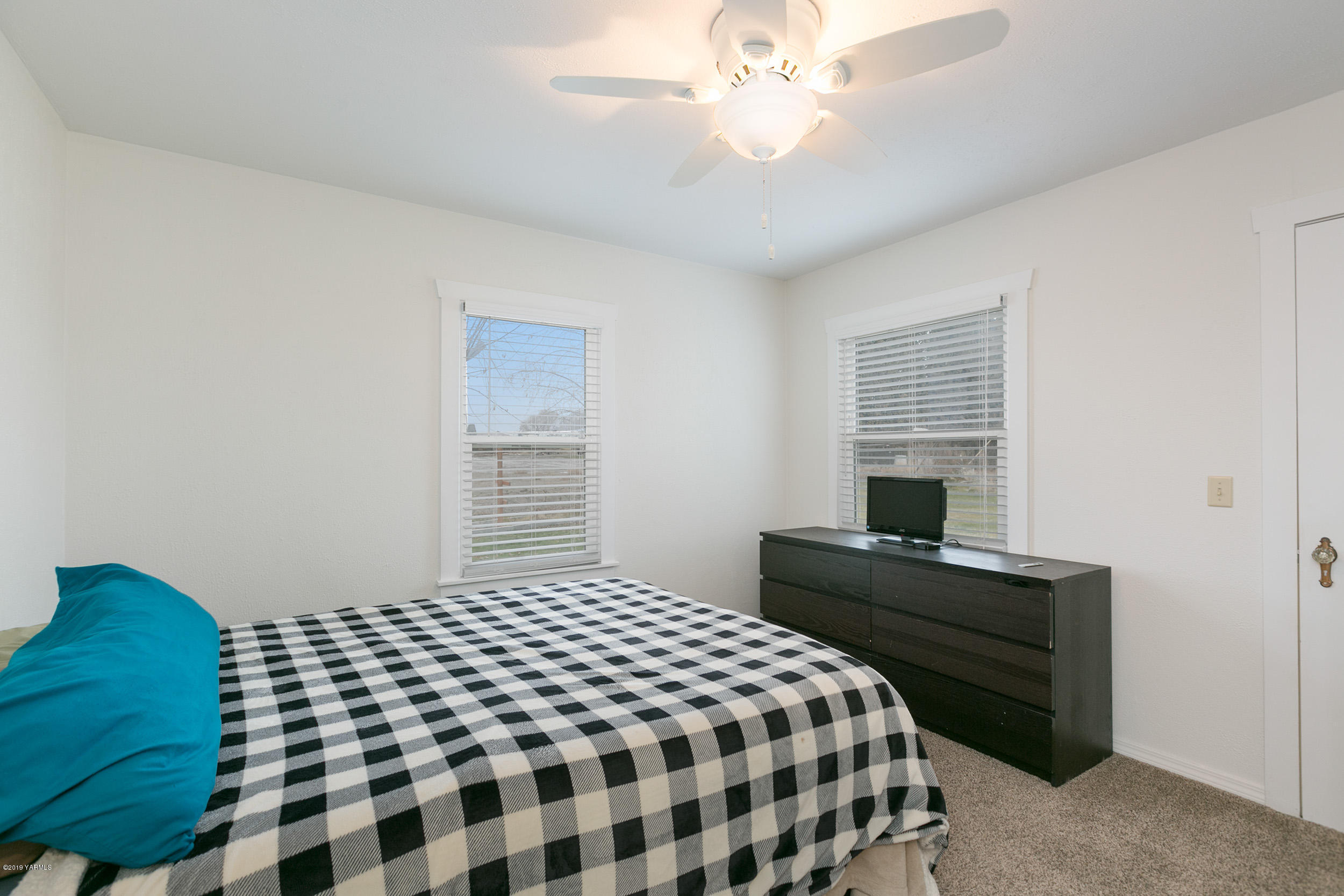 11130 Estes Road Yakima, WA 98908 - Photo 12 of 16 a bedroom with a bed and a chandelier