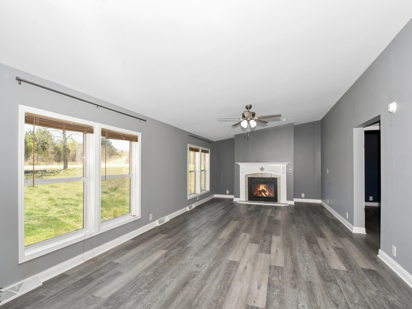 18530 West 3000N Road Reddick, IL 60961 - Photo 13 of 40 an empty room with windows fireplace and wooden floor