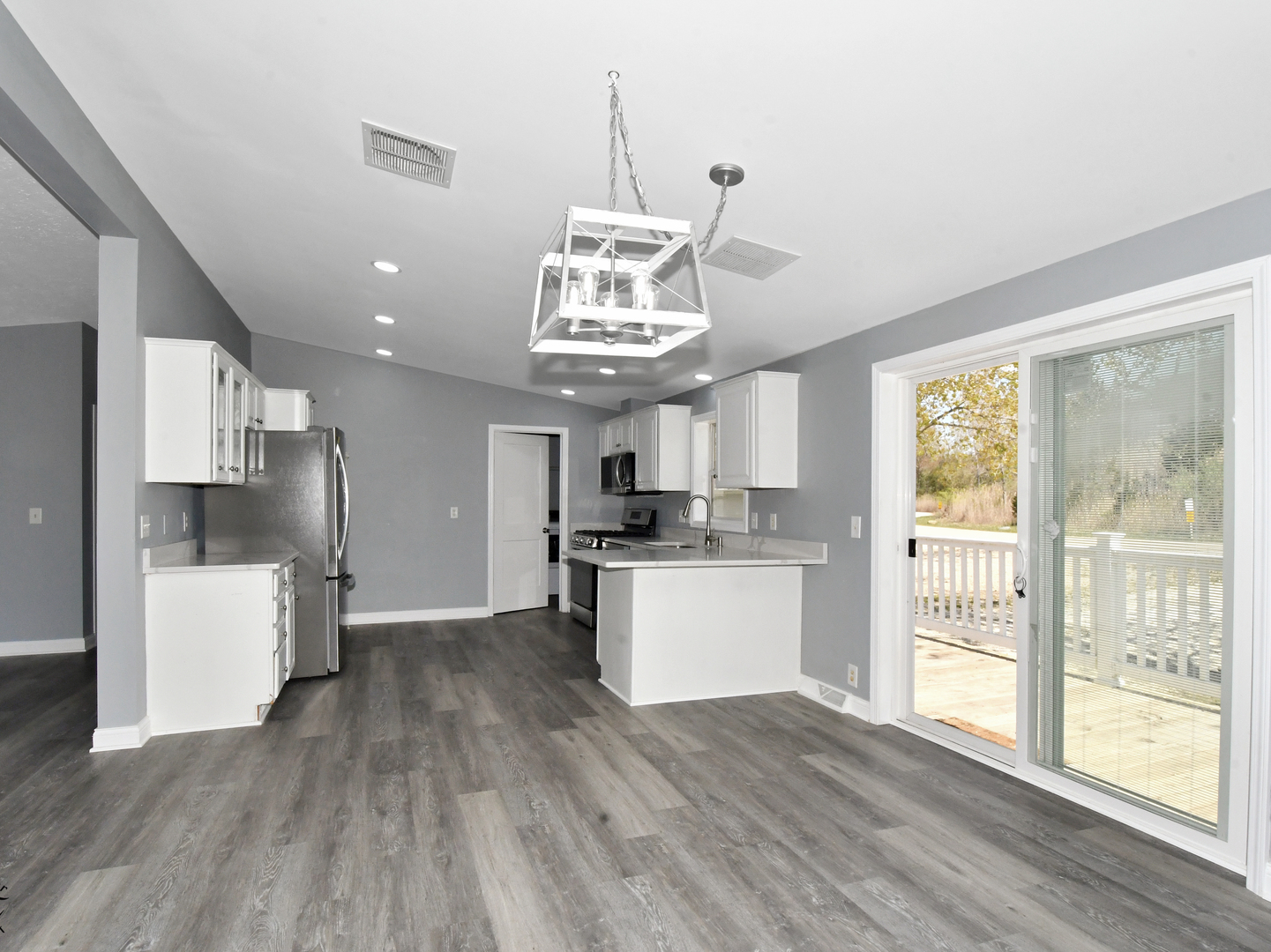 18530 West 3000N Road Reddick, IL 60961 - Photo 16 of 40 a kitchen with stainless steel appliances granite countertop a refrigerator a stove top oven a sink dishwasher and white cabinets with wooden floor