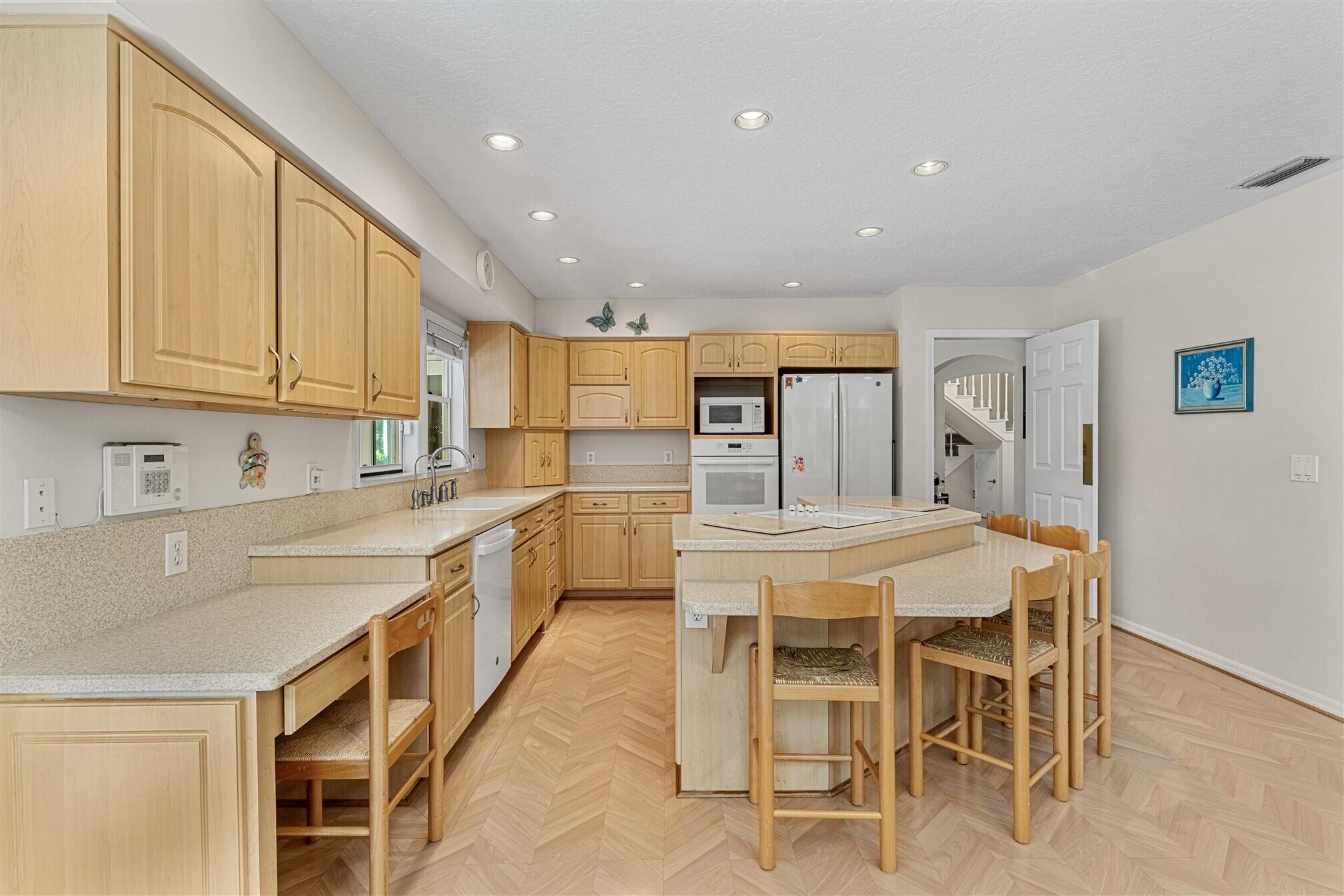 3660 Brennan Drive Melbourne, FL 32934 - Photo 18 of 71 a large kitchen with kitchen island granite countertop lots of white cabinets a sink and appliances