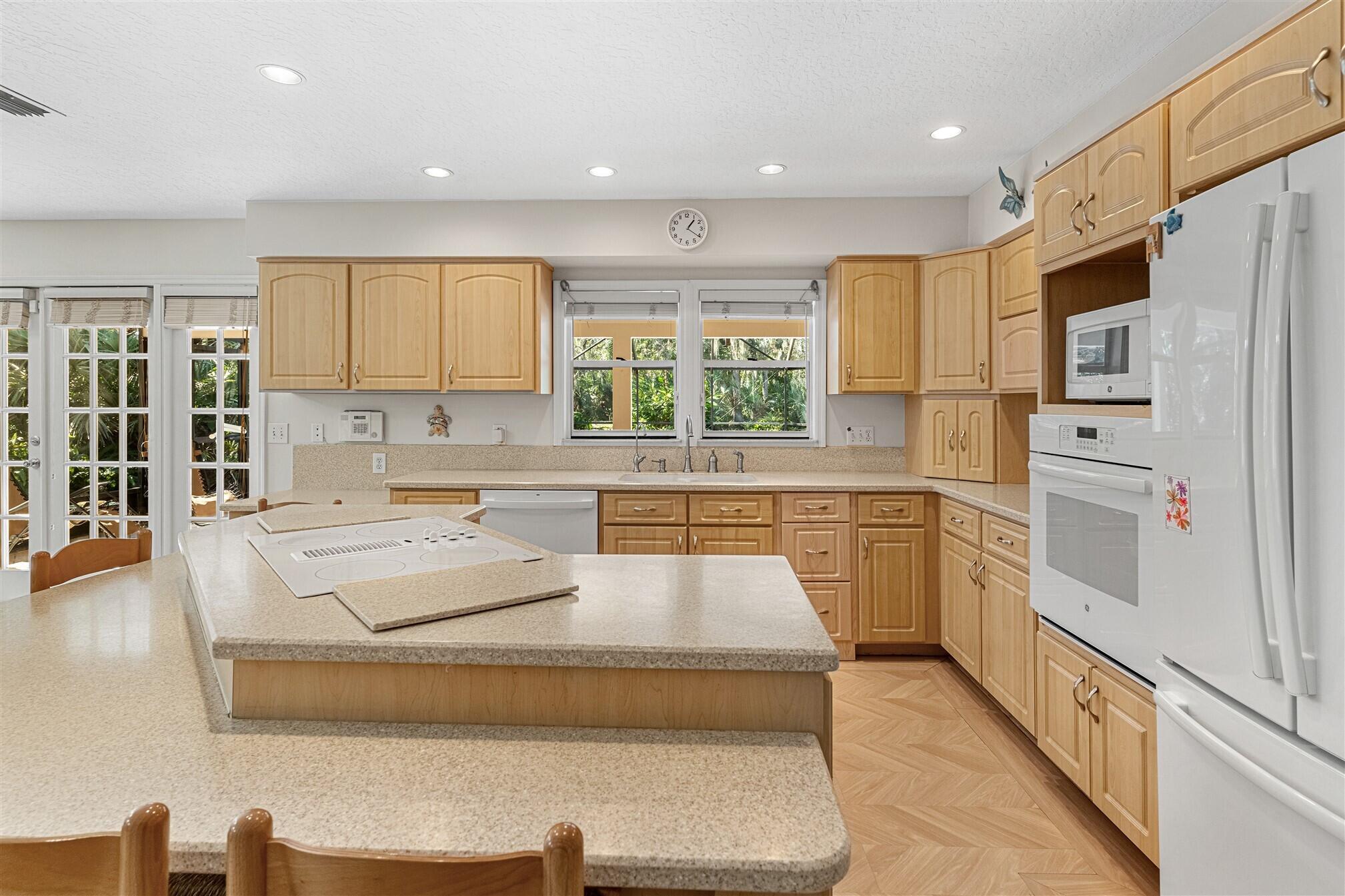 3660 Brennan Drive Melbourne, FL 32934 - Photo 20 of 71 a kitchen with white cabinets and white appliances