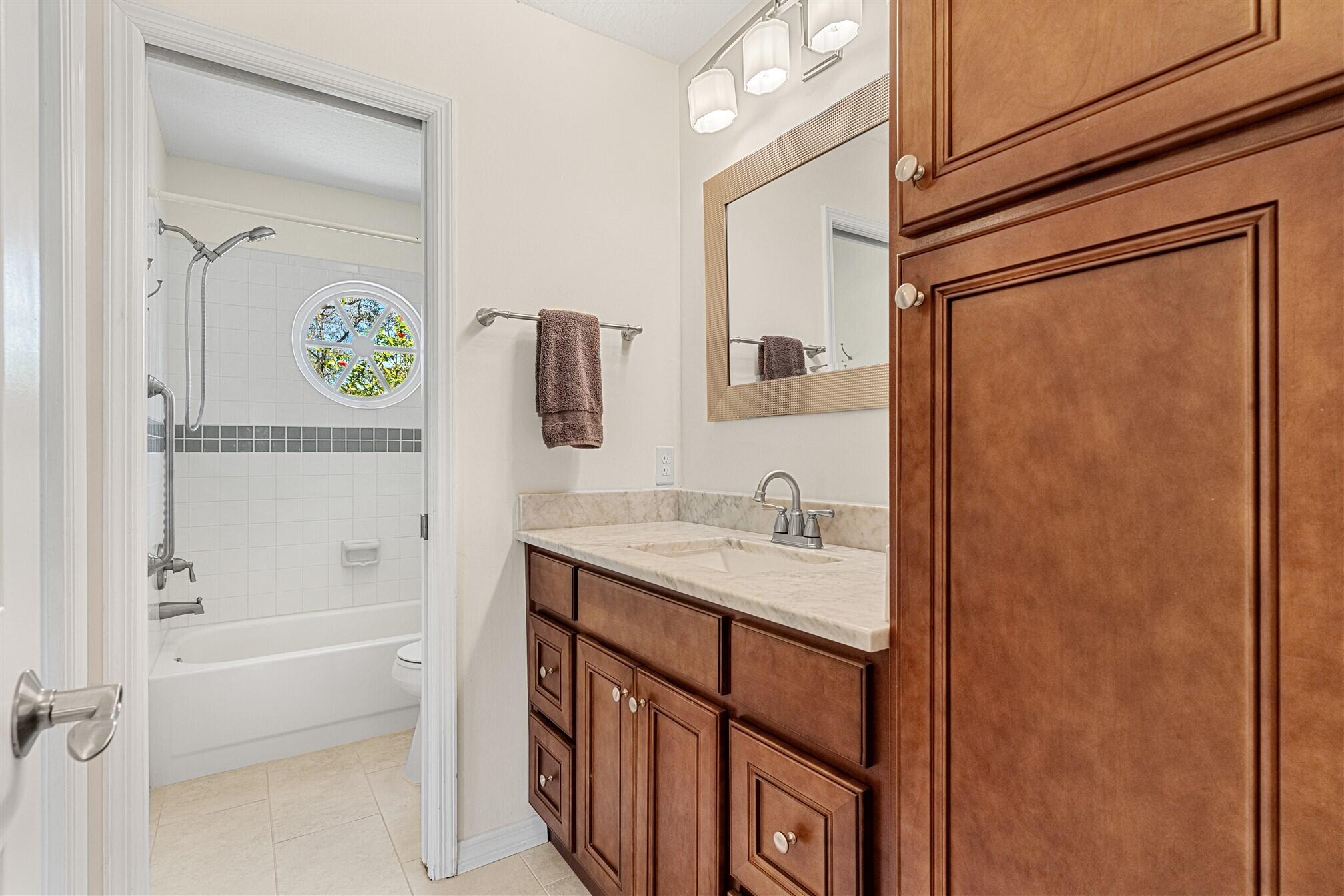 3660 Brennan Drive Melbourne, FL 32934 - Photo 30 of 71 a bathroom with a granite countertop sink a mirror and a bathtub