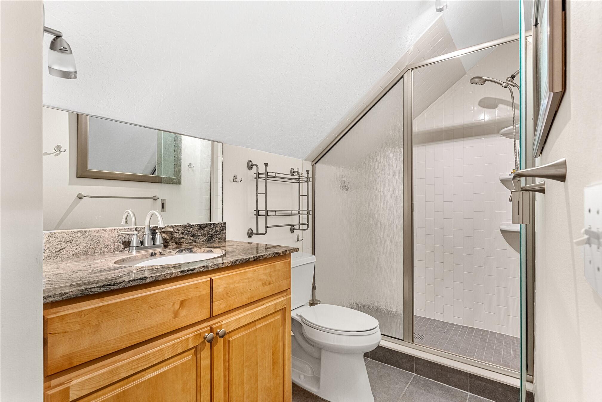 3660 Brennan Drive Melbourne, FL 32934 - Photo 38 of 71 a bathroom with a granite countertop sink toilet mirror and shower
