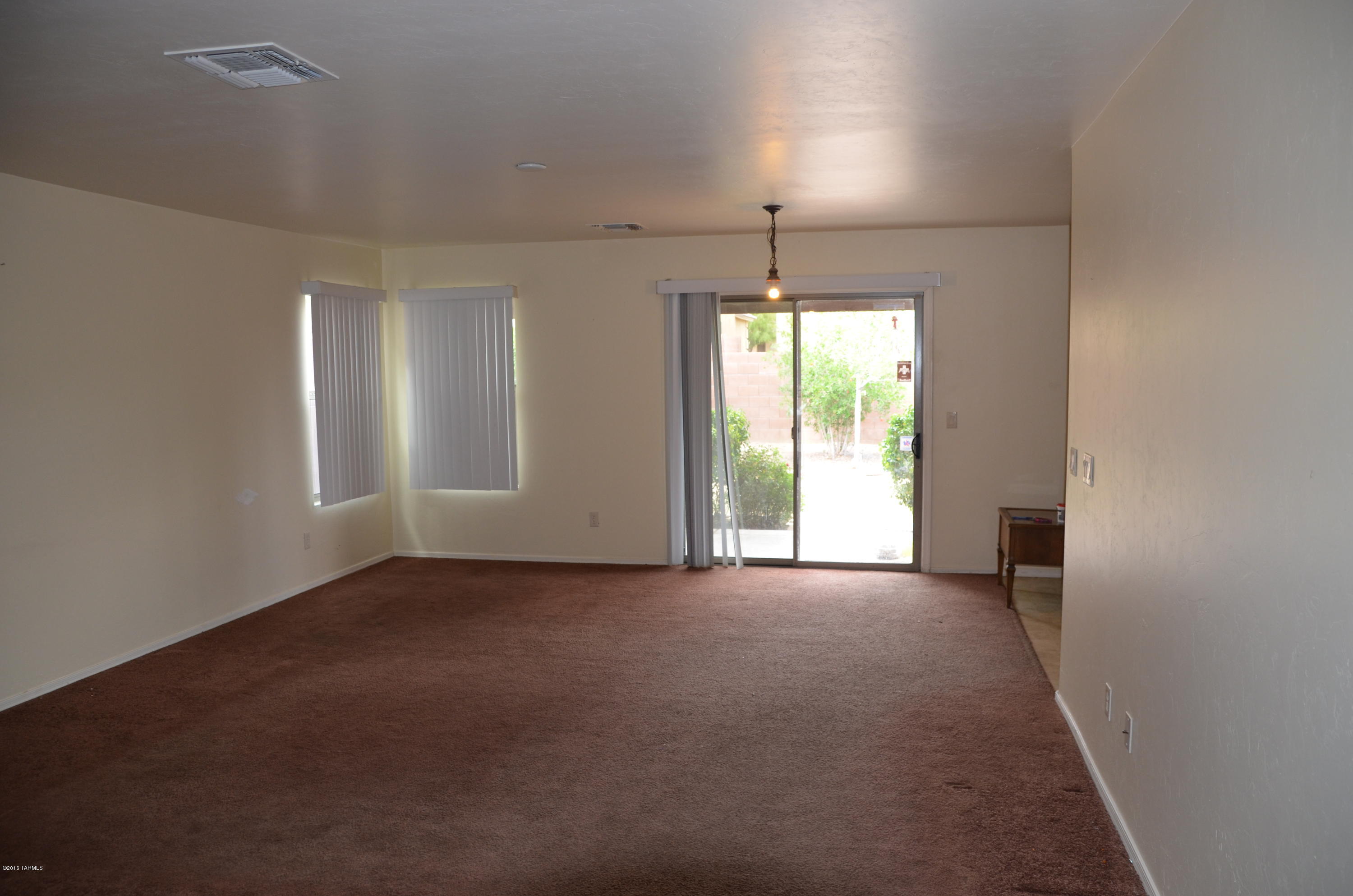 698 West Ash Ridge Drive Green Valley, AZ 85614 - Photo 8 of 19 an empty room with windows and chandelier fan