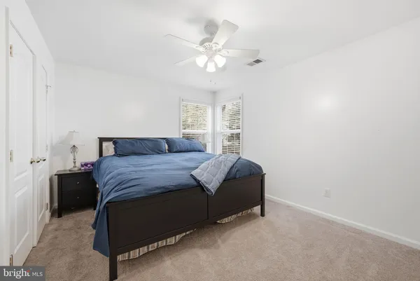a bedroom with a large bed and a ceiling fan