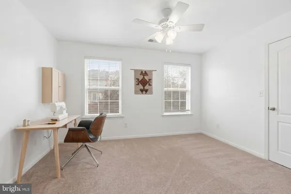 a view of a workspace with furniture and a window