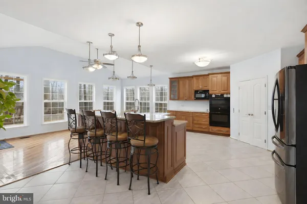 a view of a dining room and livingroom with furniture a rug a flat screen tv a rug and a chandelier
