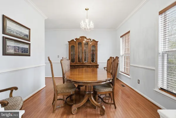 a dining room with furniture a chandelier and wooden floor